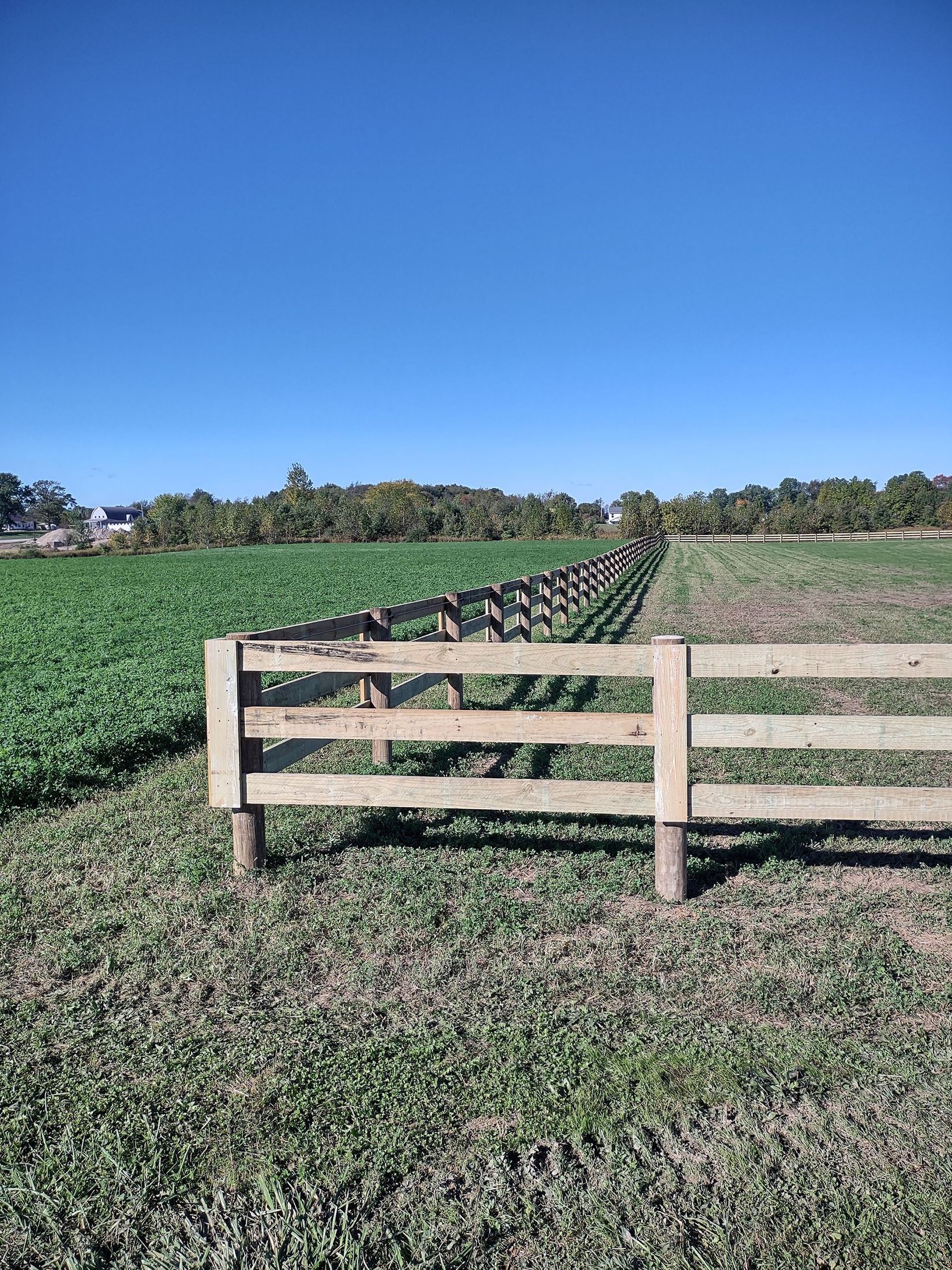 There is a wooden fence in the middle of a field.