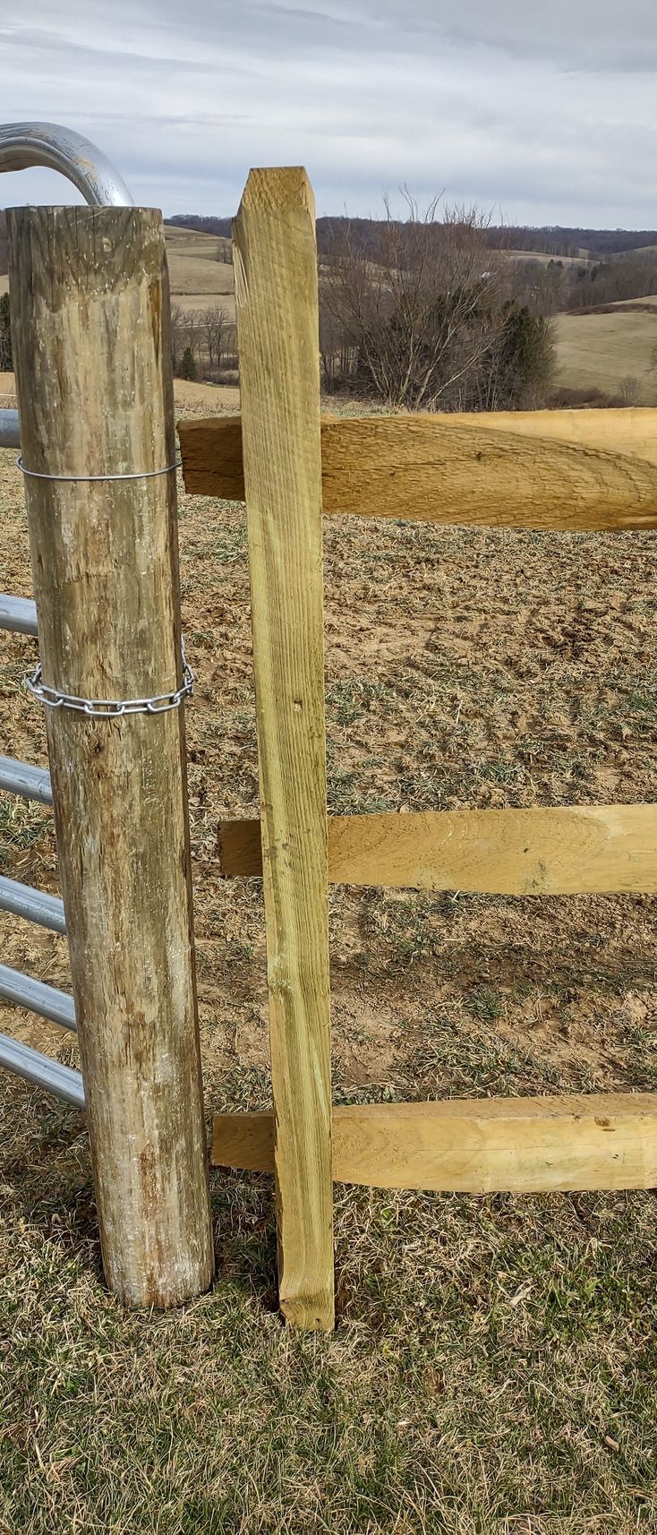 A wooden fence is sitting in the middle of a field.