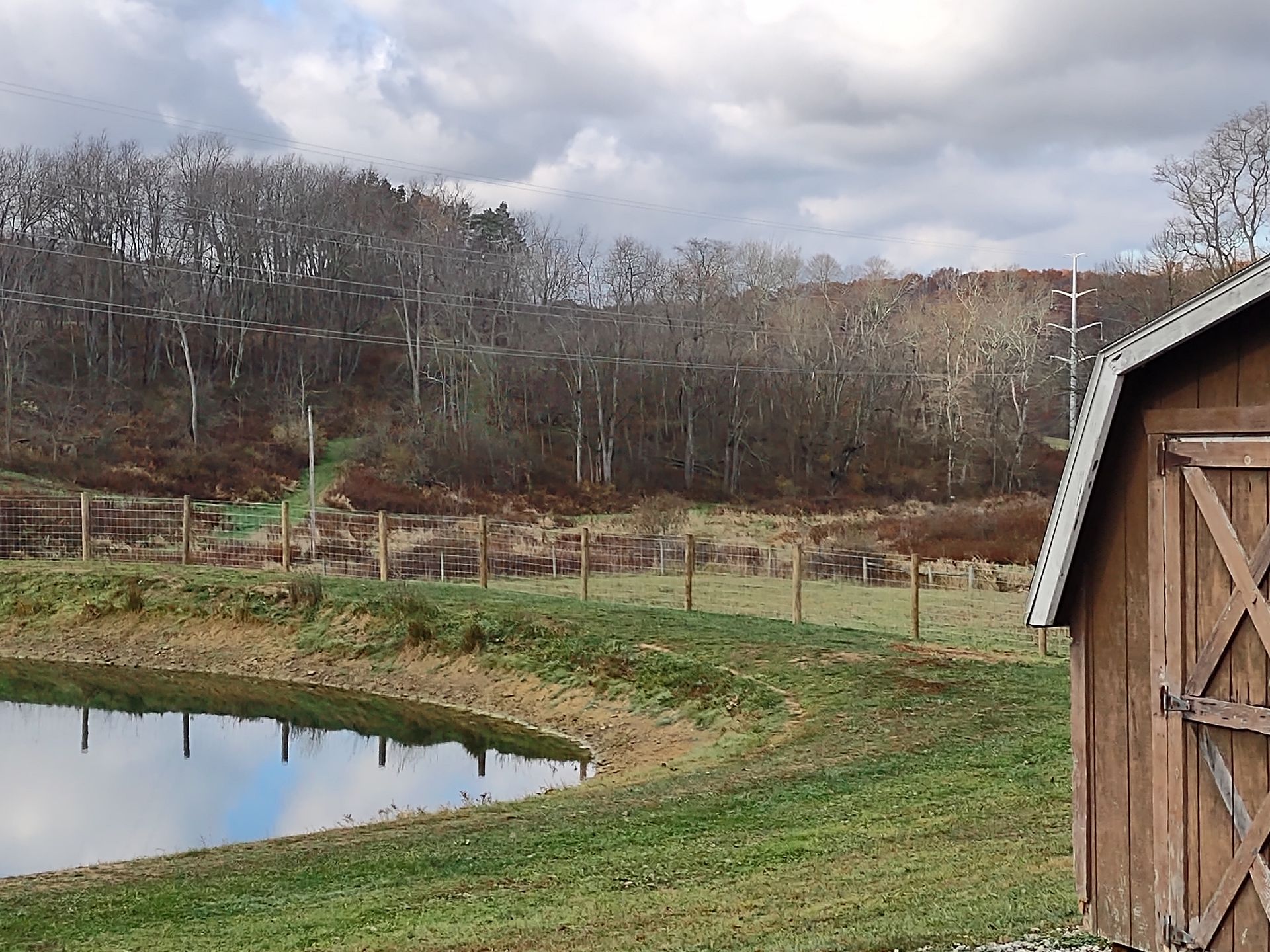 A barn with a pond in front of it