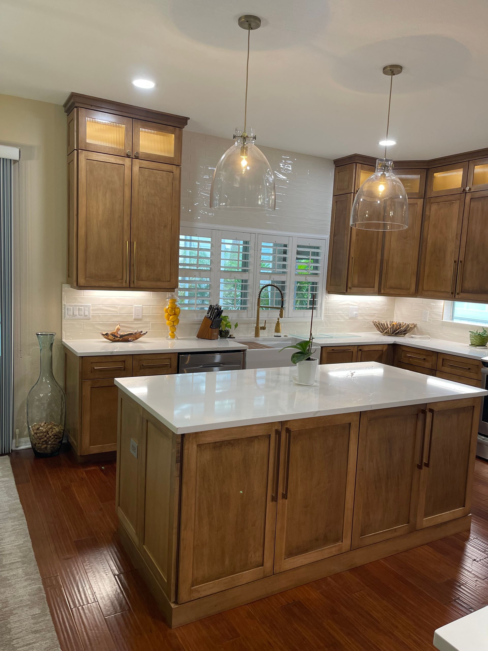 A kitchen with wooden cabinets and white counter tops