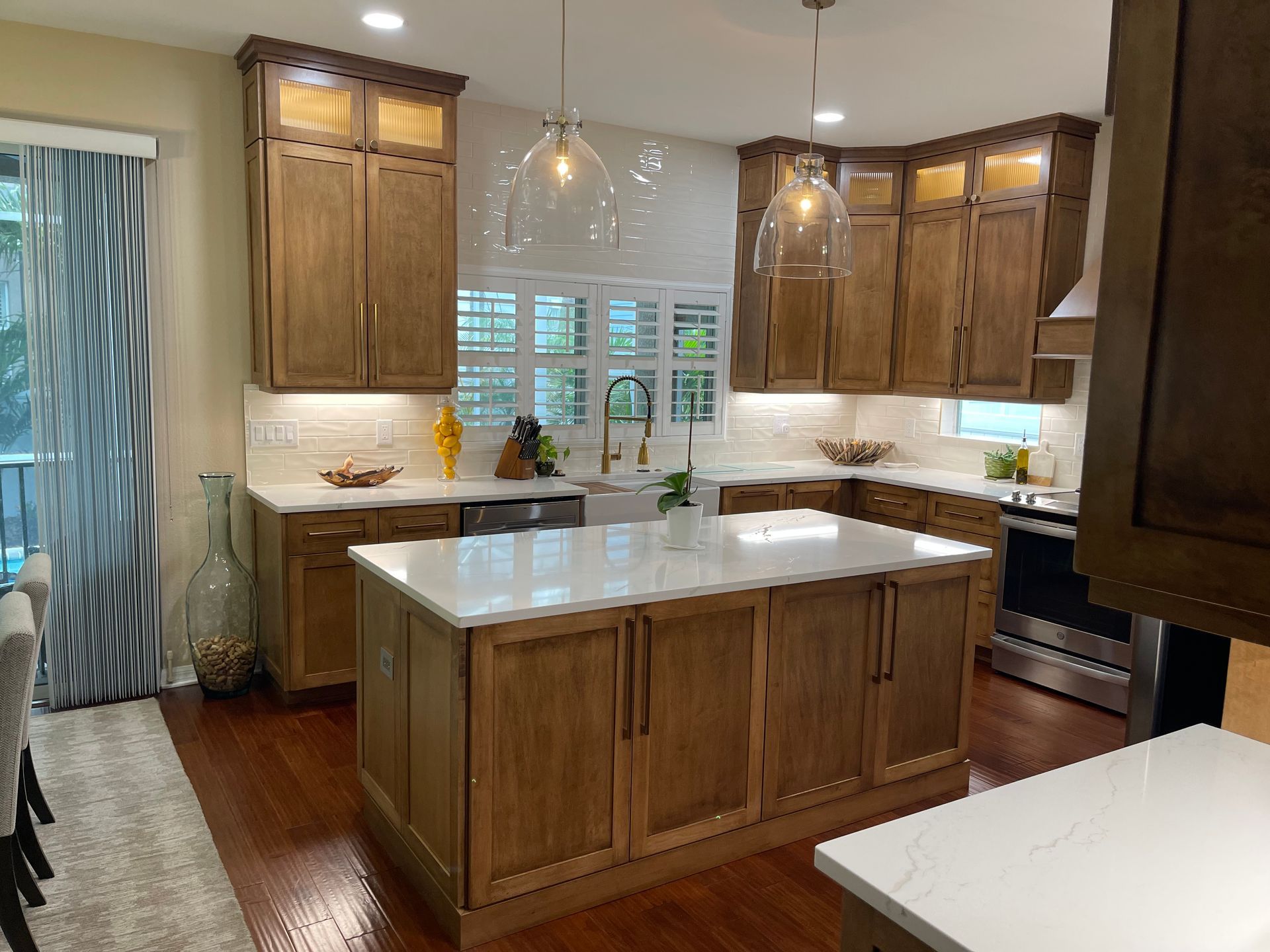 A kitchen with wooden cabinets and a large island in the middle.