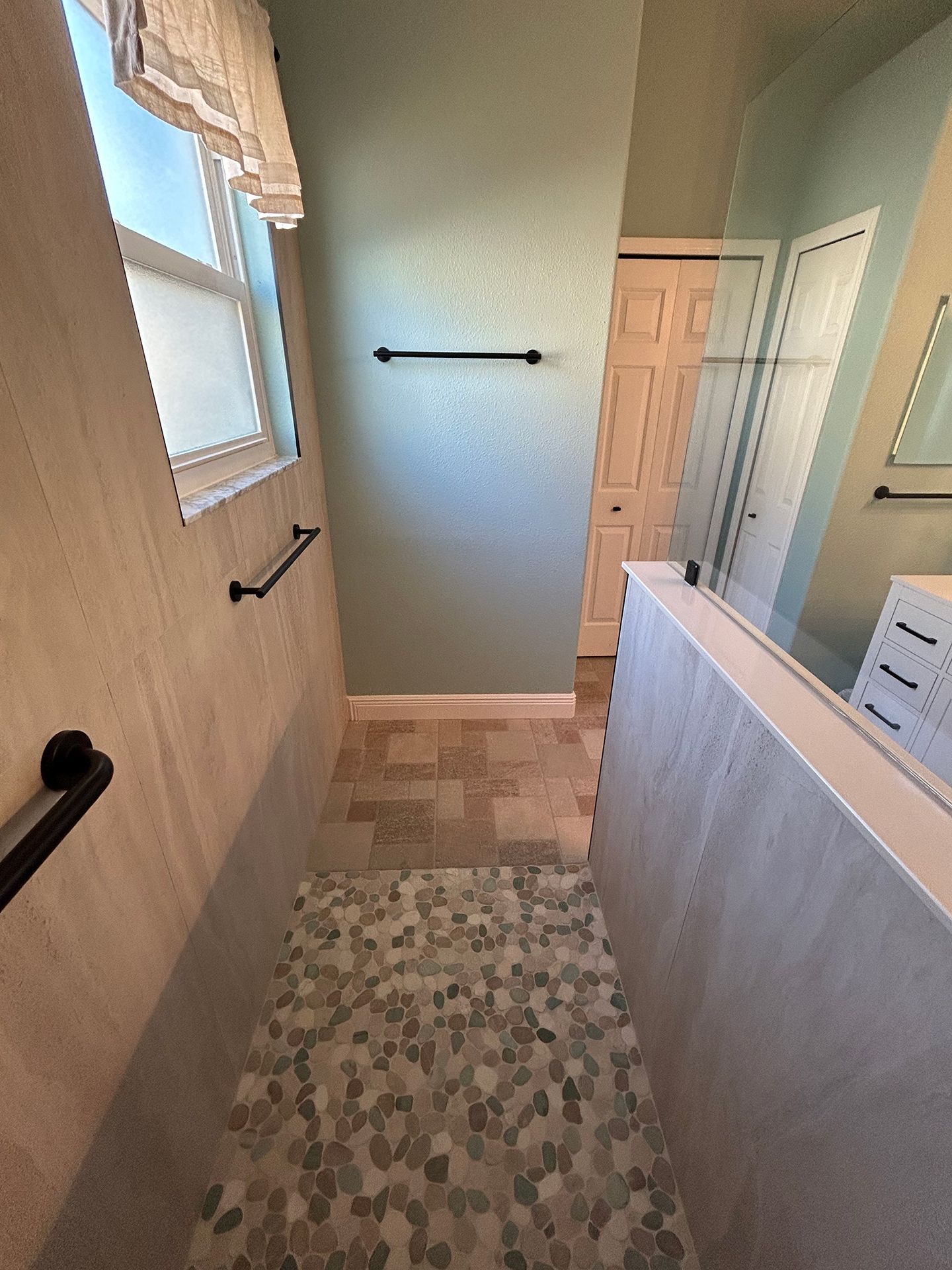 A bathroom with a walk-in shower and a window