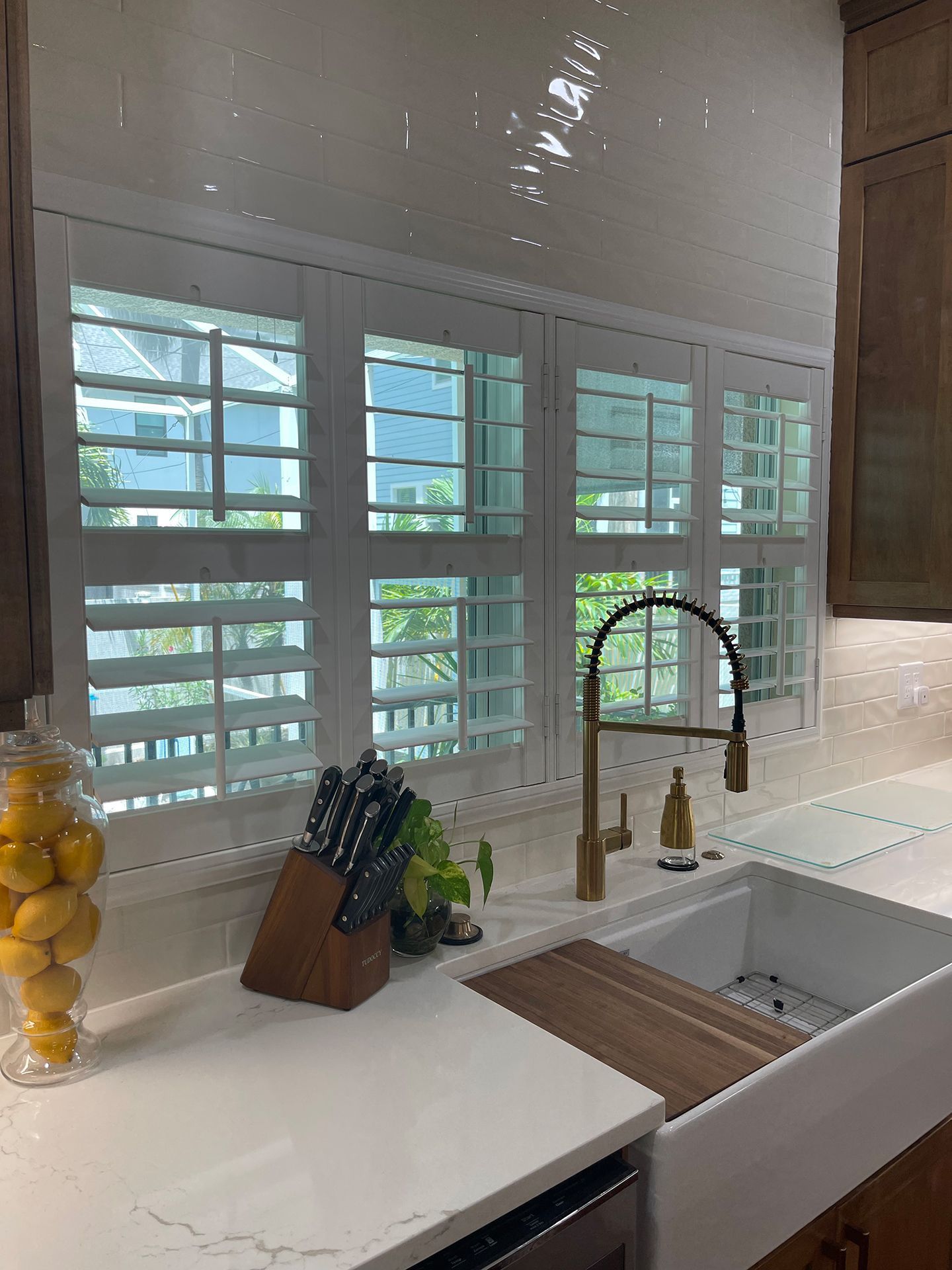 A kitchen with a sink and a window with shutters