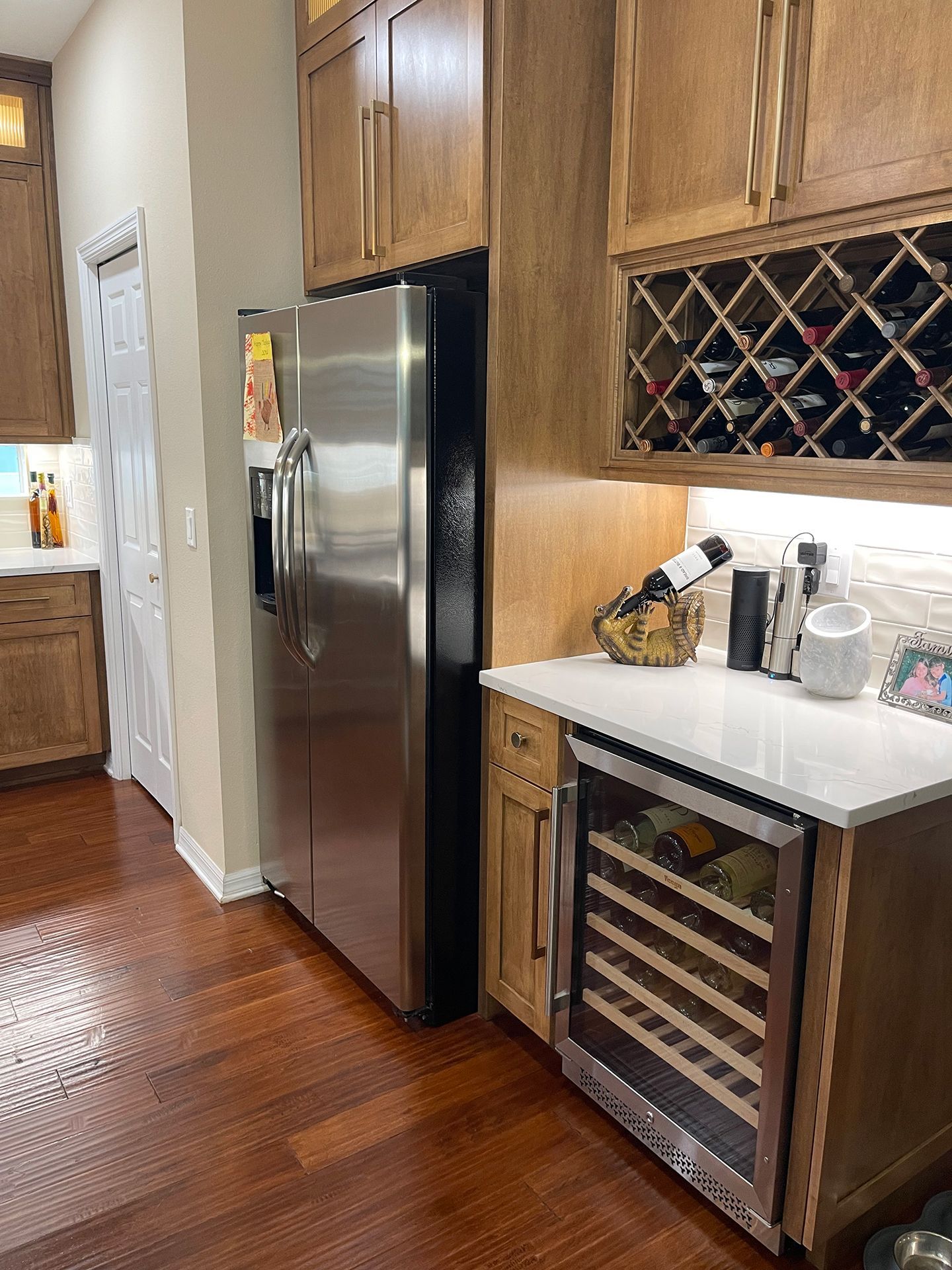 A kitchen with a stainless steel refrigerator and a wine cooler