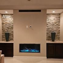 Living room wall with stone accents, built-in fireplace, and flanking cabinets. 