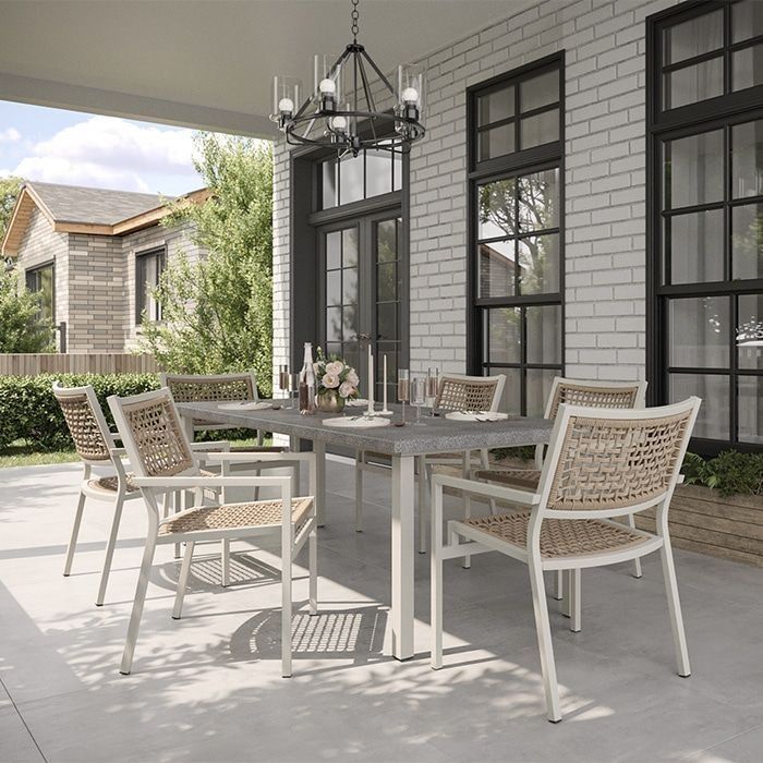 Outdoor dining set: a rectangular table and six woven-back chairs on a patio with a chandelier.