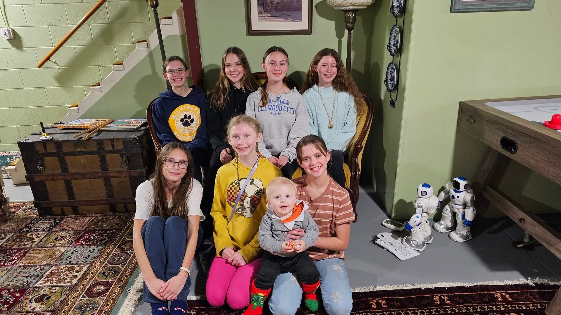 A group of people are posing for a picture in a living room.