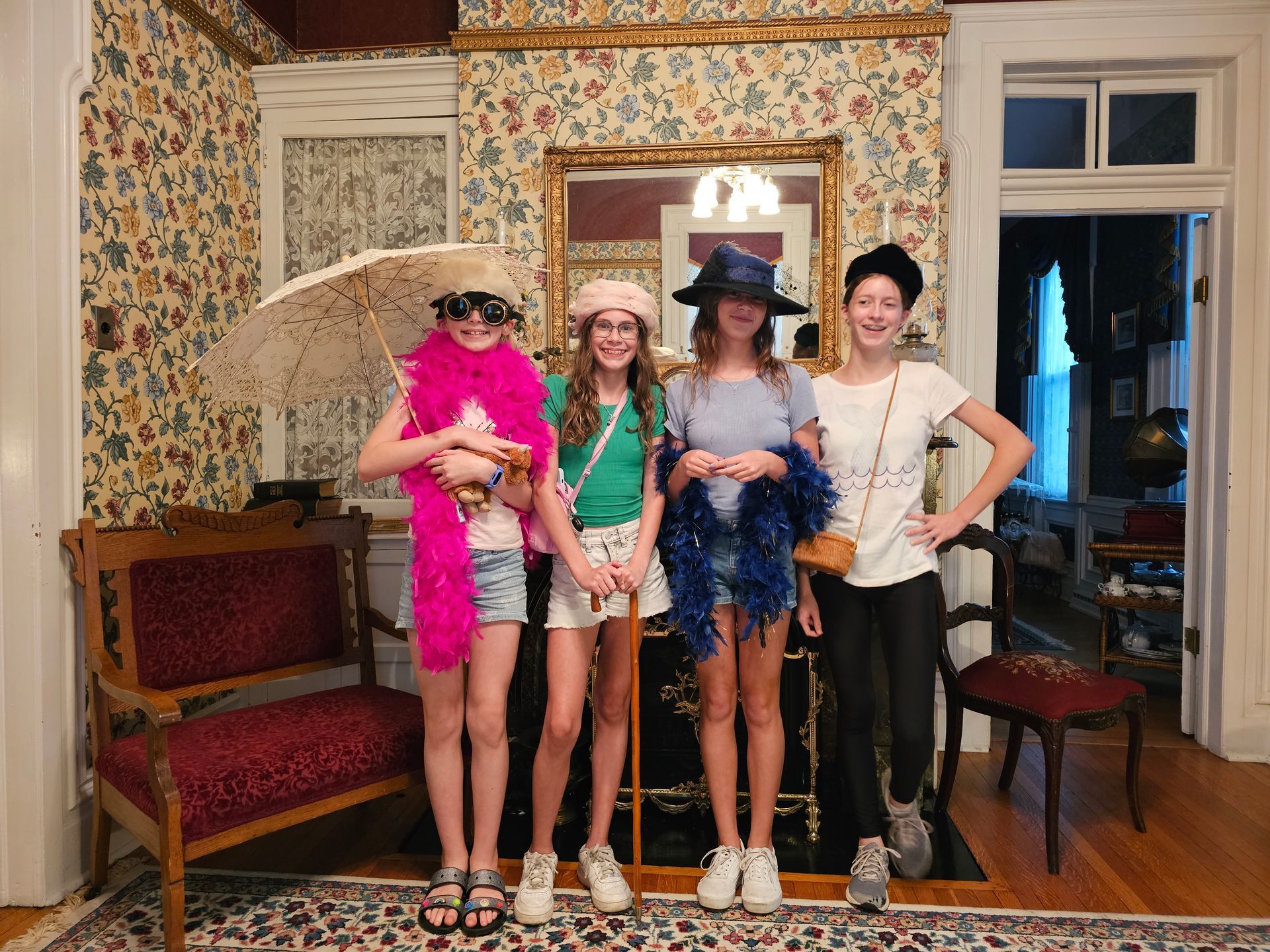 A group of young girls are posing for a picture in a living room.