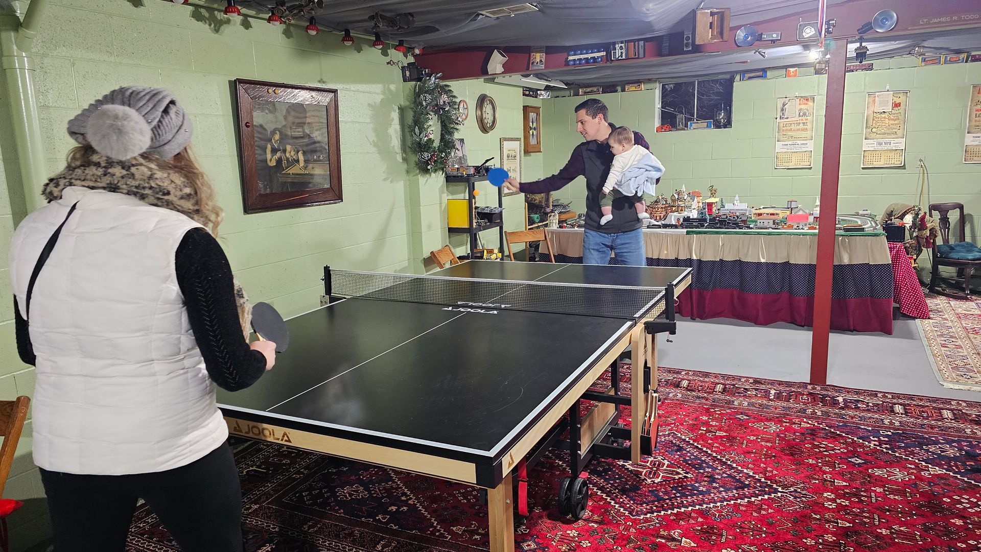 A group of people are playing ping pong in a basement.