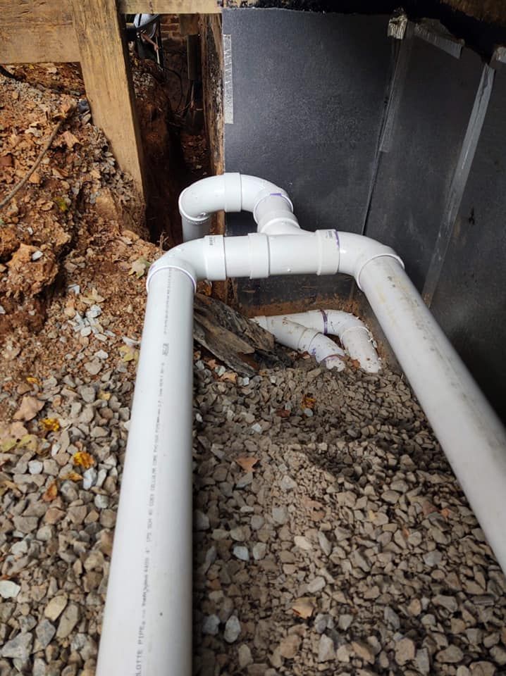 A couple of white pipes sitting on top of a pile of gravel.