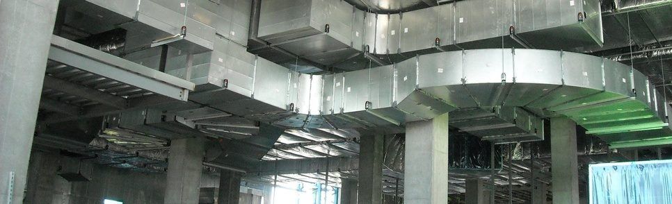 A large room with a lot of ducts hanging from the ceiling.