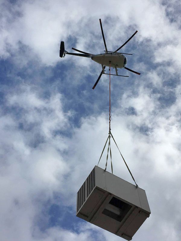 A helicopter is lifting a box in the air