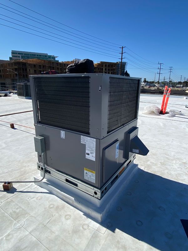 A large air conditioner is sitting on top of a roof.