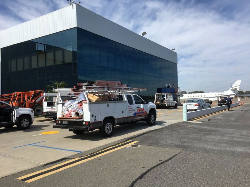 A white truck is parked in front of a large building.