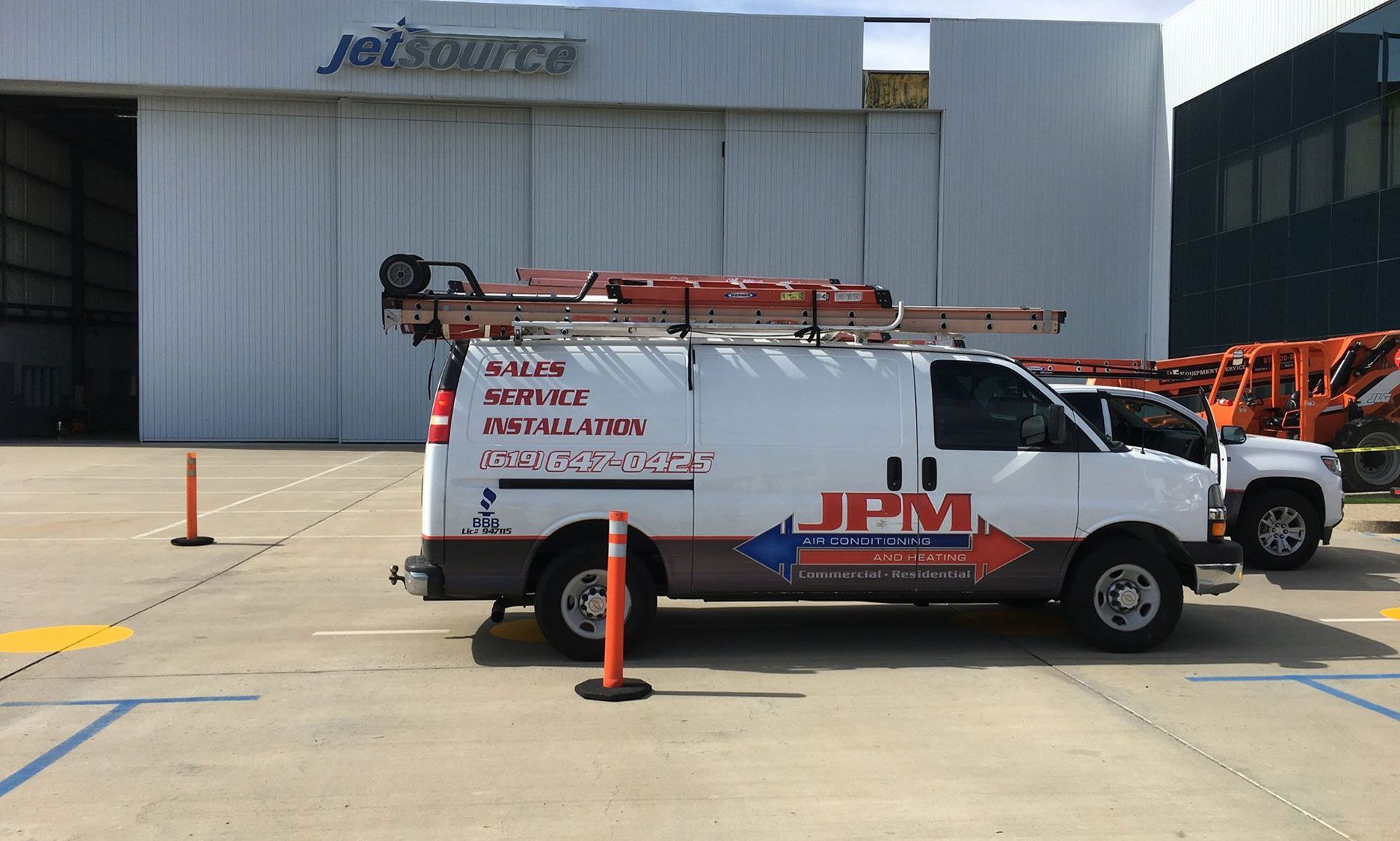 A jpm van is parked in front of a building