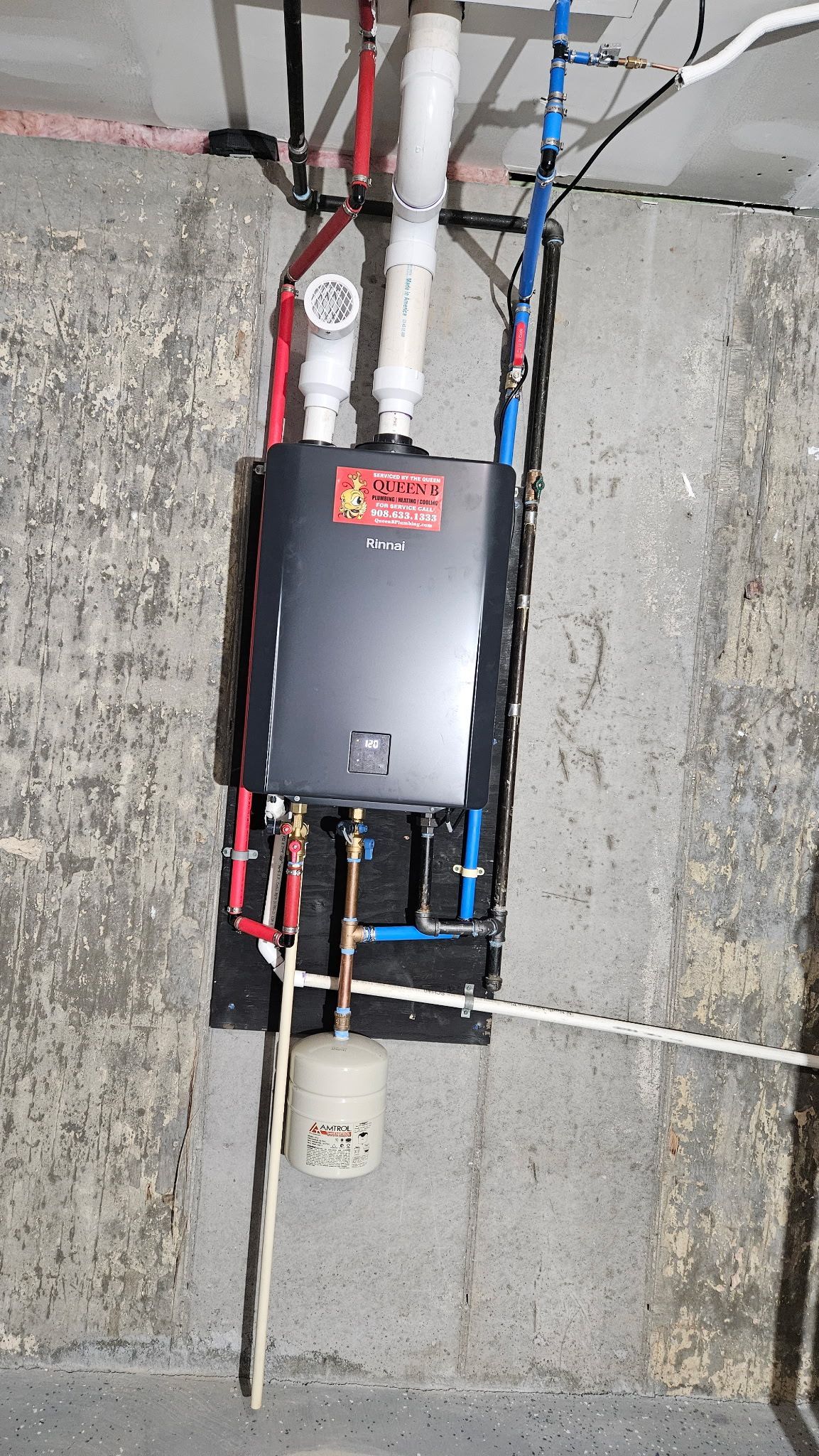 Electrical panel with exposed wiring mounted on a concrete wall in a utility space