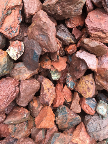 Red and brown landscaping rocks, piled closely together.