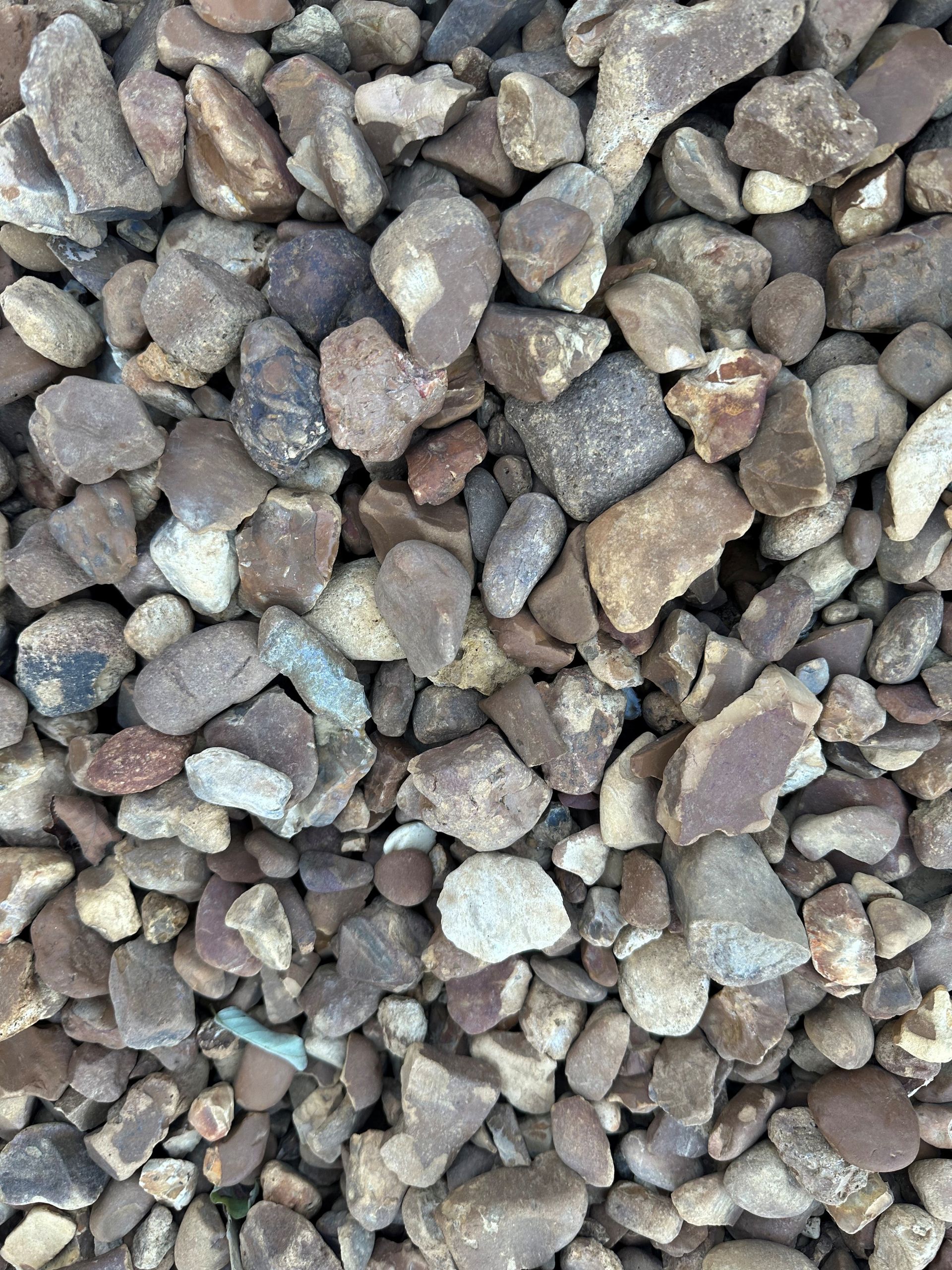 Gravel, mostly brown and tan with some reddish hues, fills the frame.