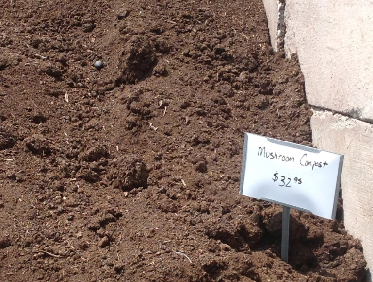 Pile of mushroom compost with a sign that reads