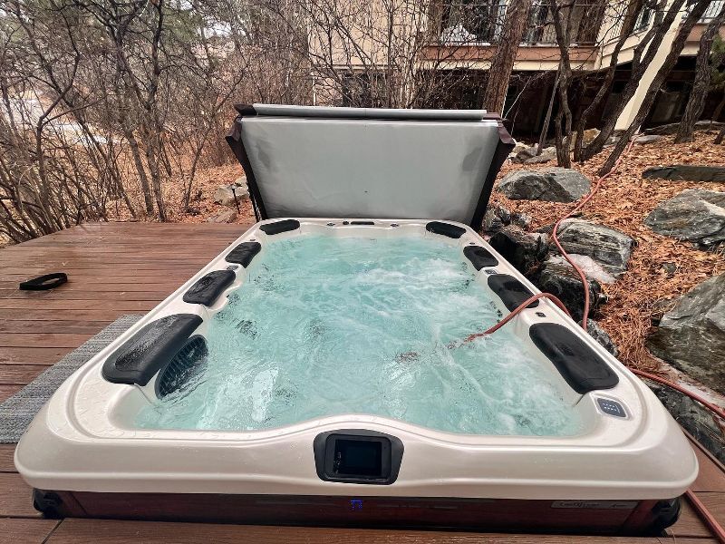 A hot tub is sitting on top of a wooden deck.