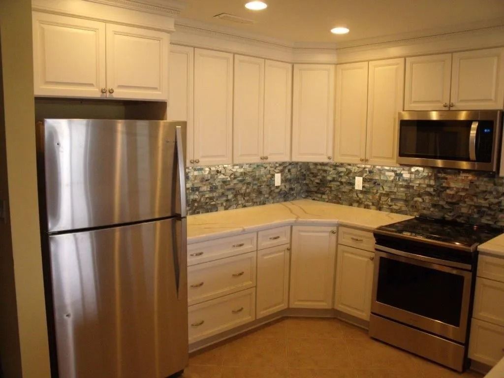 Modern kitchen with stainless steel appliances, cream cabinets, and granite countertops.