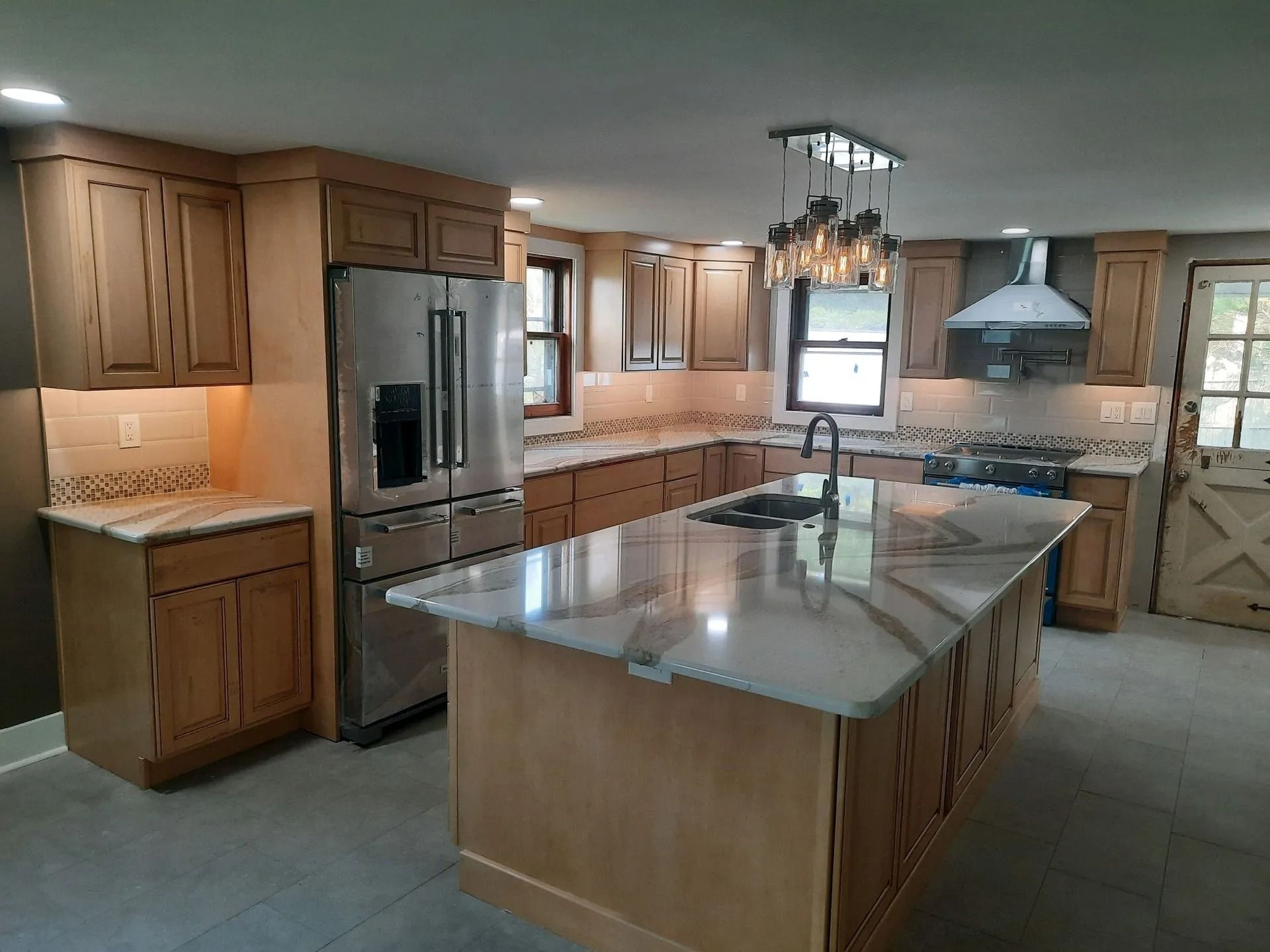 Spacious kitchen with wooden cabinets, stainless steel appliances, and a large granite island.