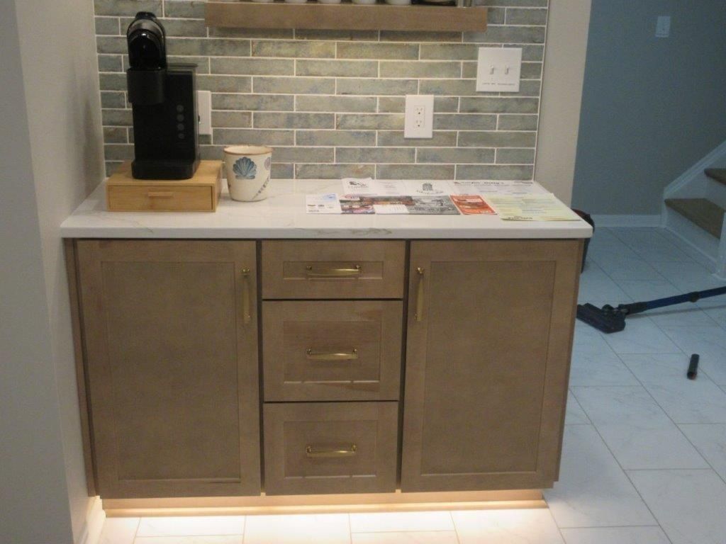 Kitchen cabinet with a white countertop, drawers, and a black coffee maker on top