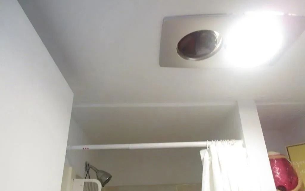 Ceiling and closet area with a round light fixture and partially open curtain.