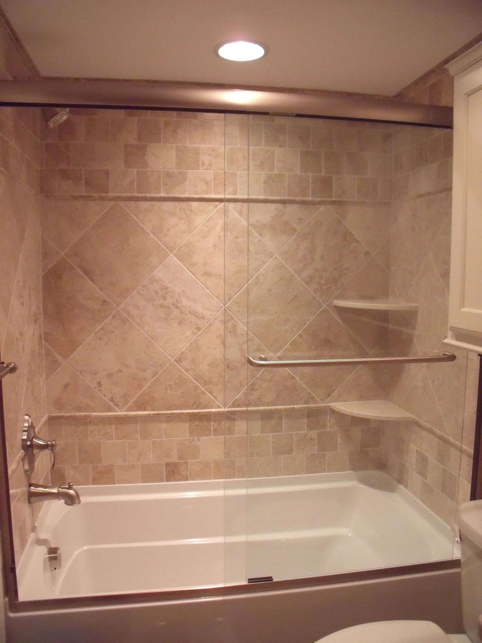 Accessible bathroom with tiled walk-in shower, grab bars, built-in bench, and bathtub.