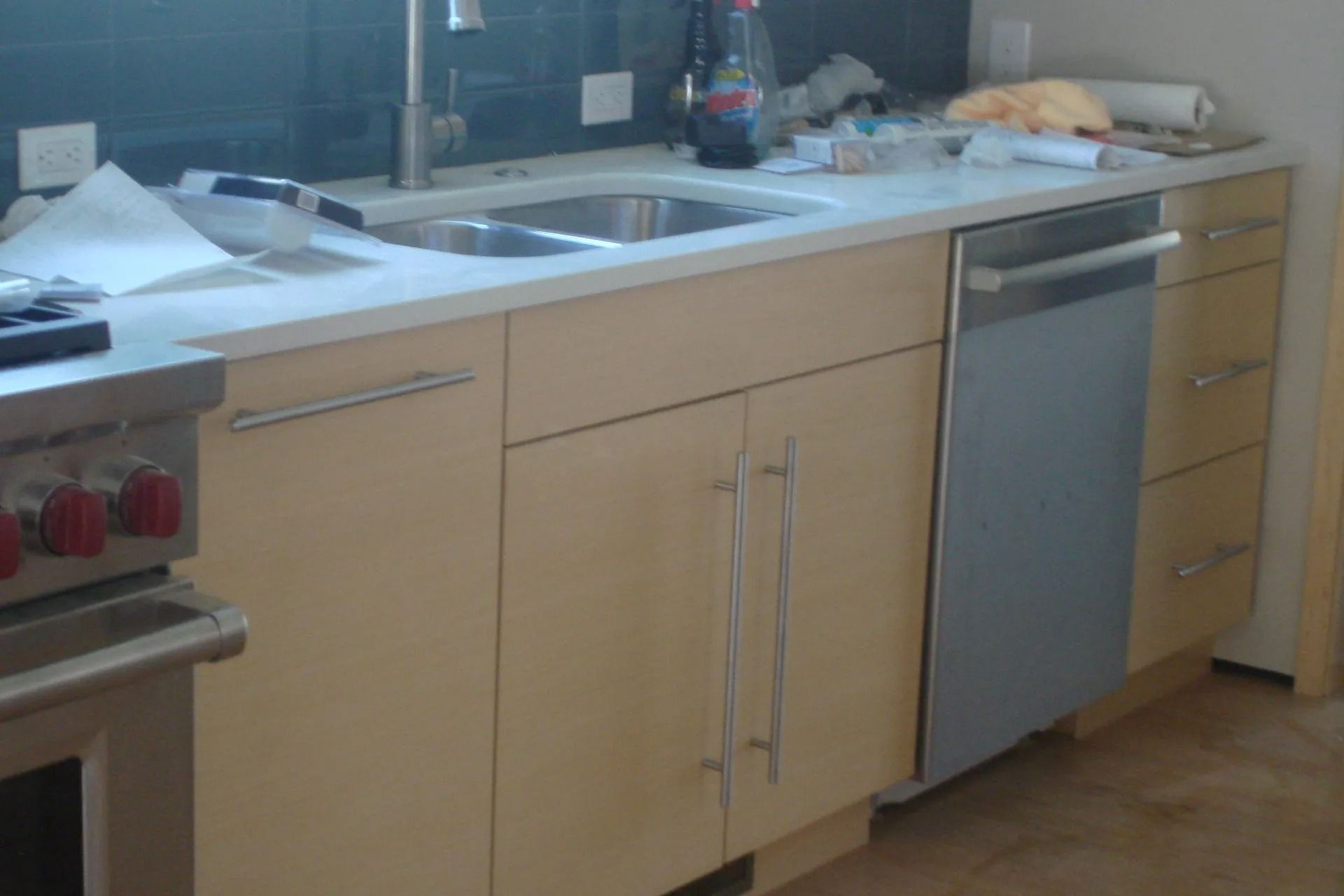 Kitchen countertop with sink, wooden cabinets, and a stainless steel dishwasher