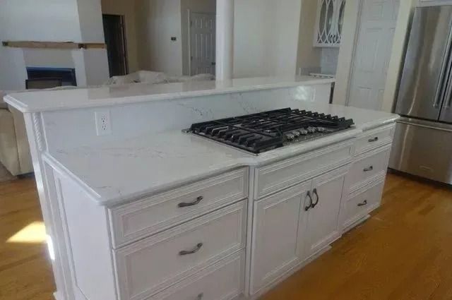White kitchen island with built-in gas cooktop and drawers in a bright room