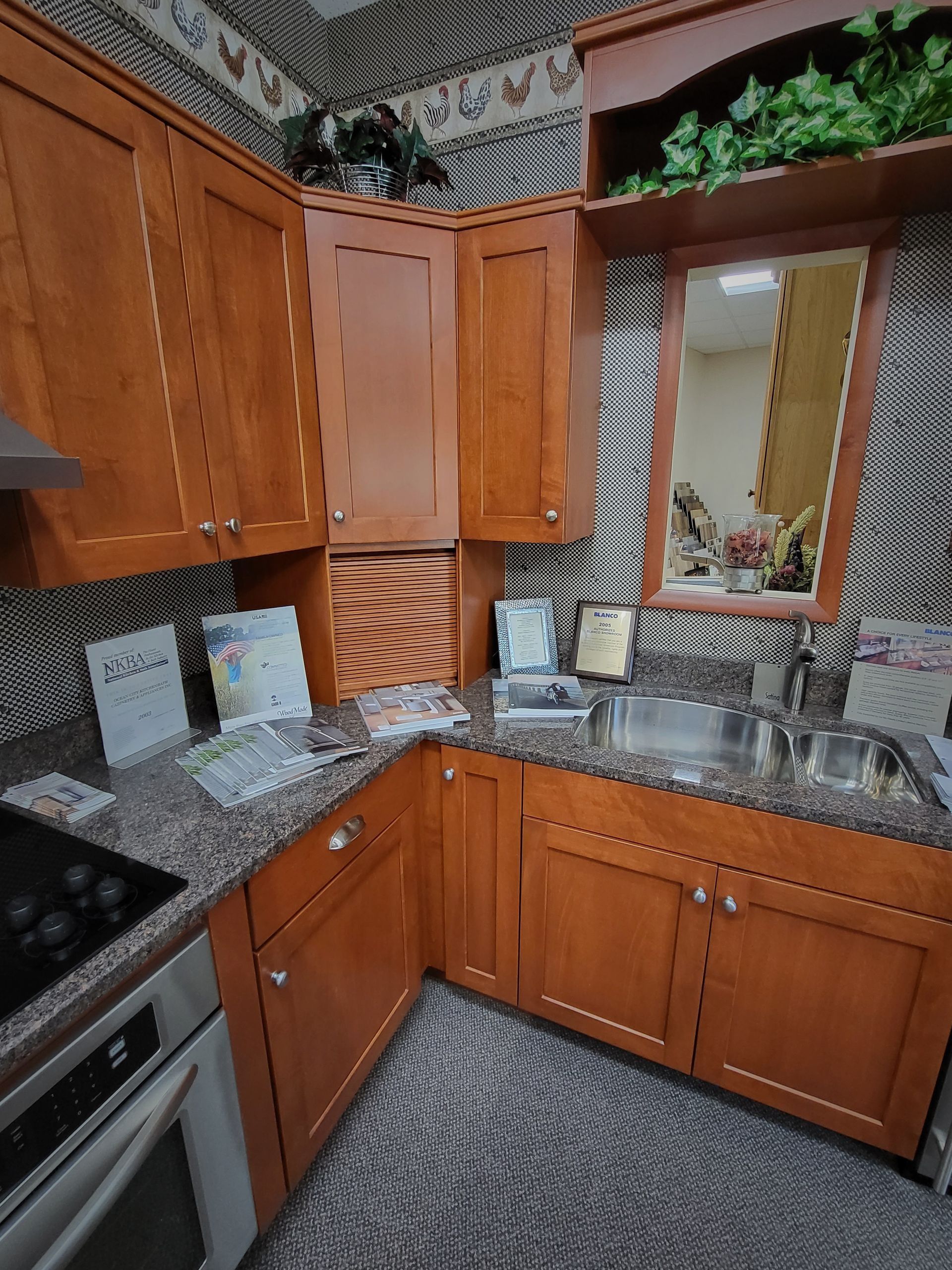Wooden kitchen with granite counters, built-in oven, and a mirrored backsplash corner.