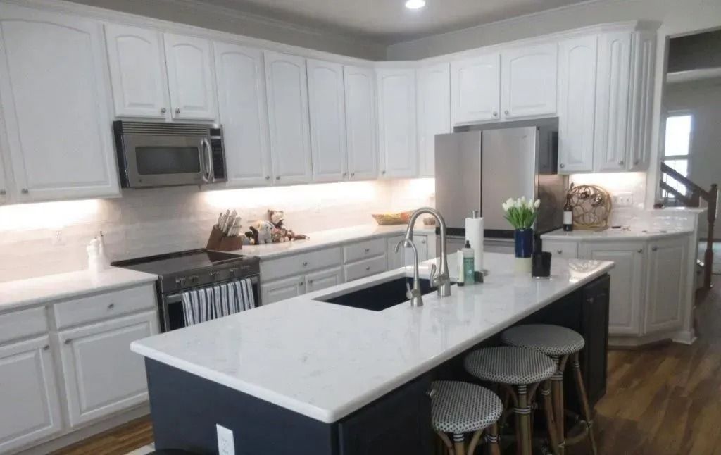 Modern white kitchen with island, stainless appliances, and stool seating