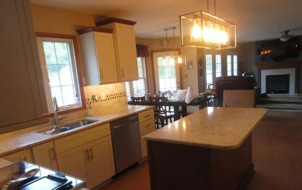 Modern kitchen with island, wood cabinets, and a chandelier in a bright open floor plan