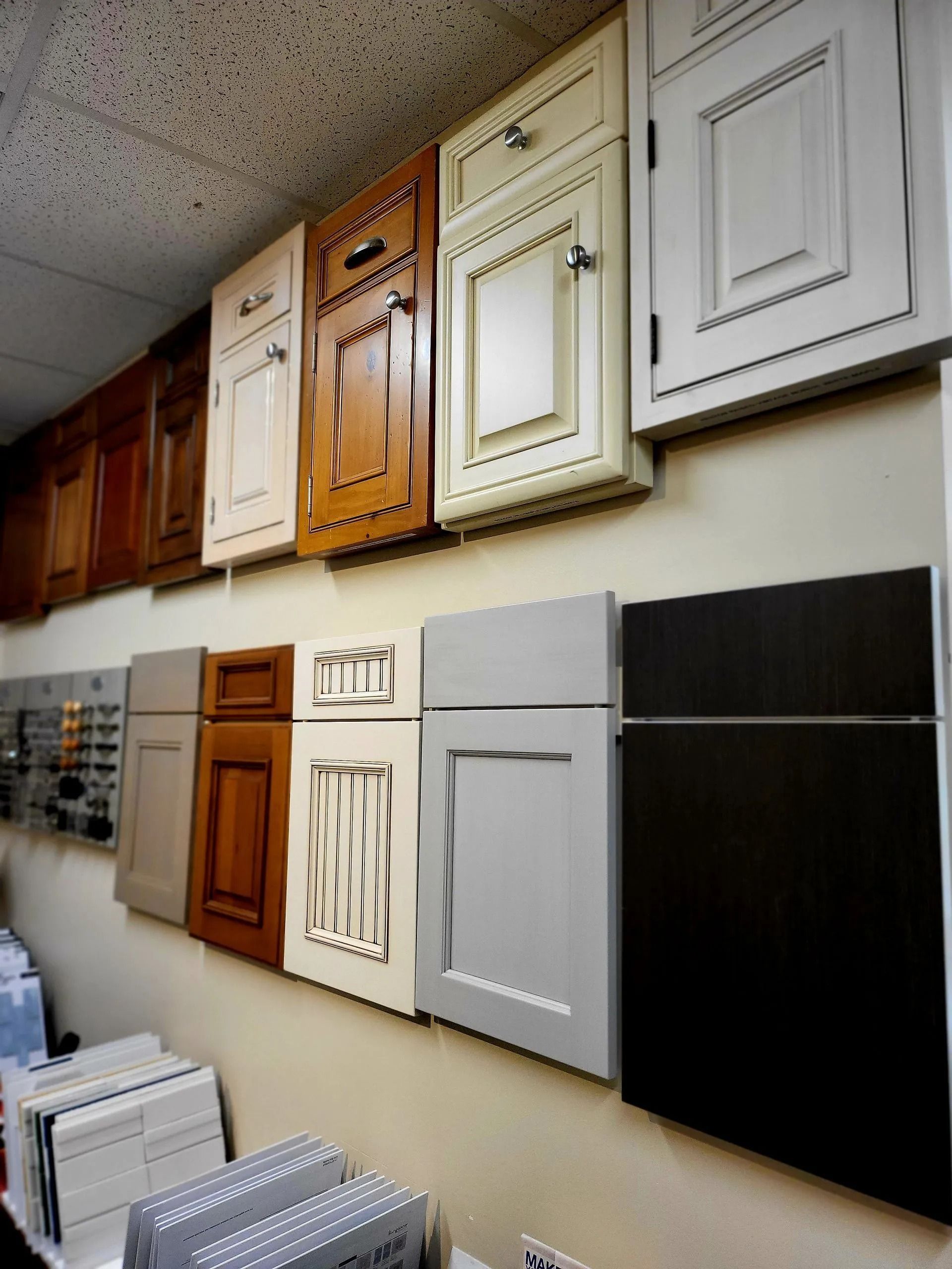 Wall display of assorted cabinet door samples in different colors and styles in a showroom