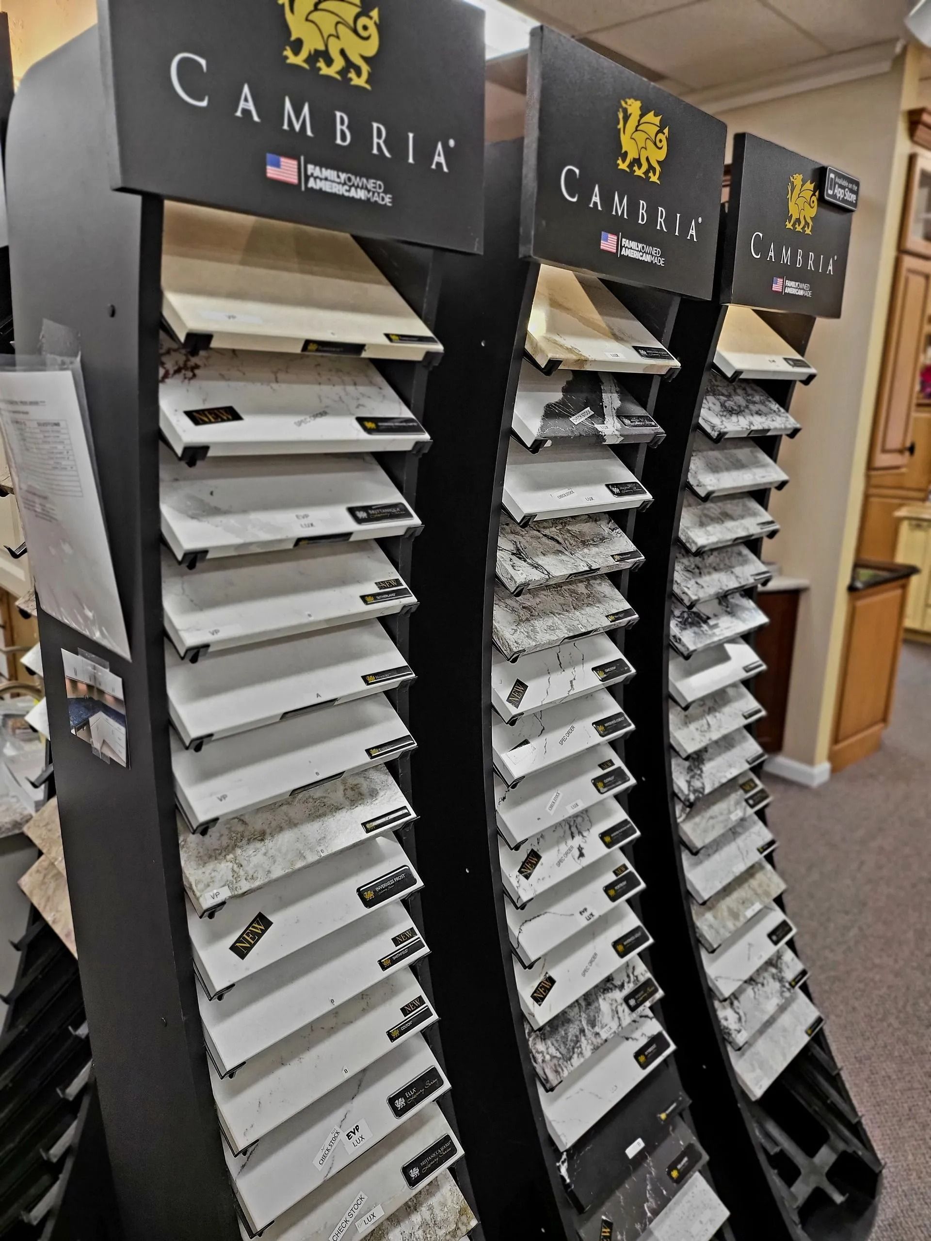 Three black paint-sample display racks in a showroom, filled with white and gray sample boards.