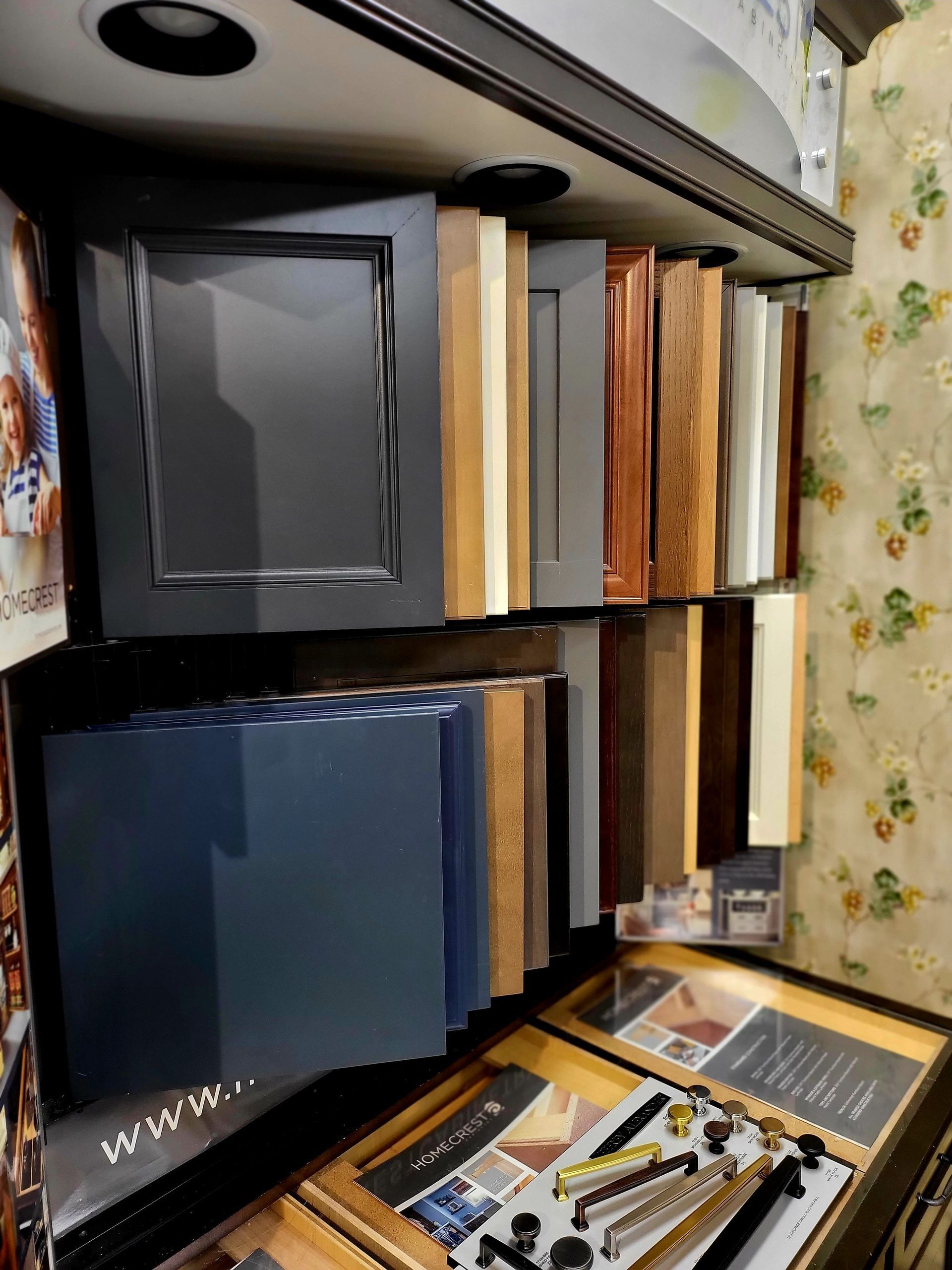 Shelves of assorted binders and boxes, with craft supplies on a desk below, in a cluttered room
