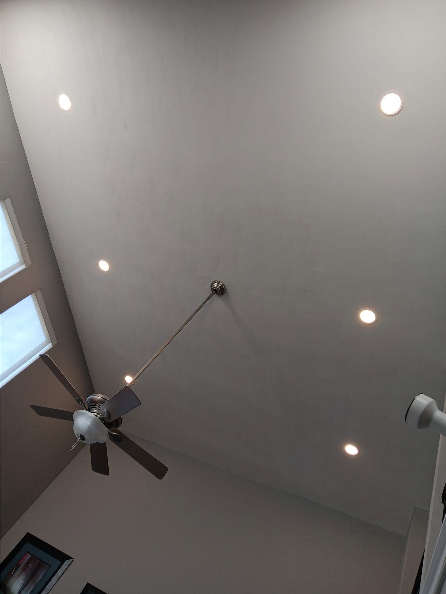 Ceiling view of a room with recessed lights, a ceiling fan, and skylights.