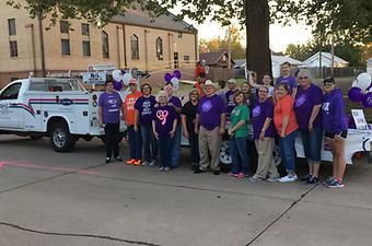 A group of people are posing for a picture in front of a truck.