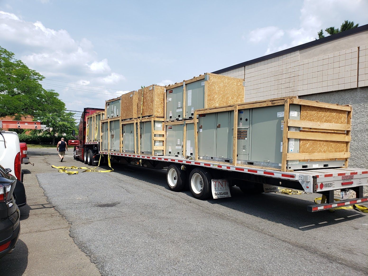 A semi truck is carrying a stack of boxes on a trailer.