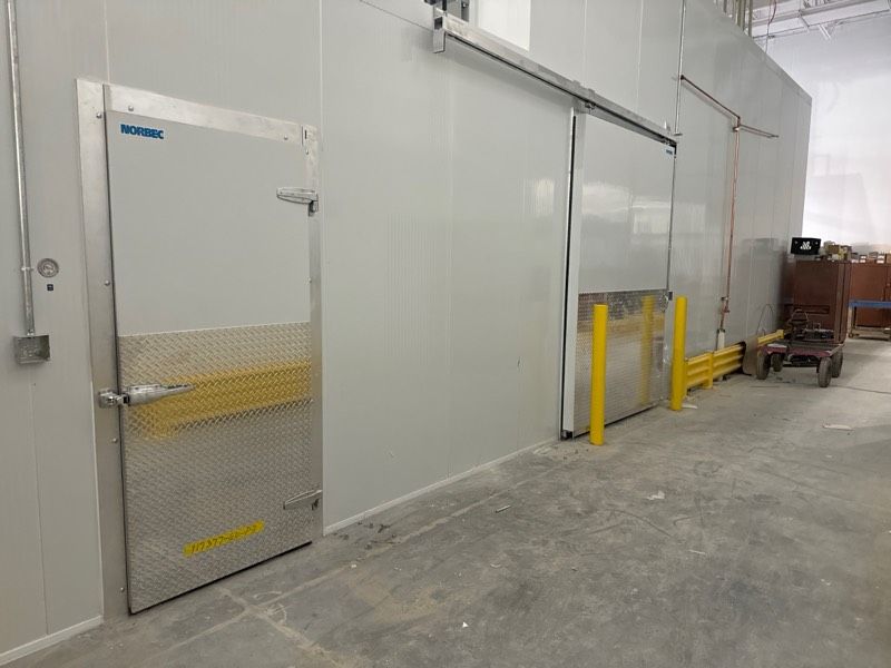 A warehouse with sliding doors and a forklift in the background.