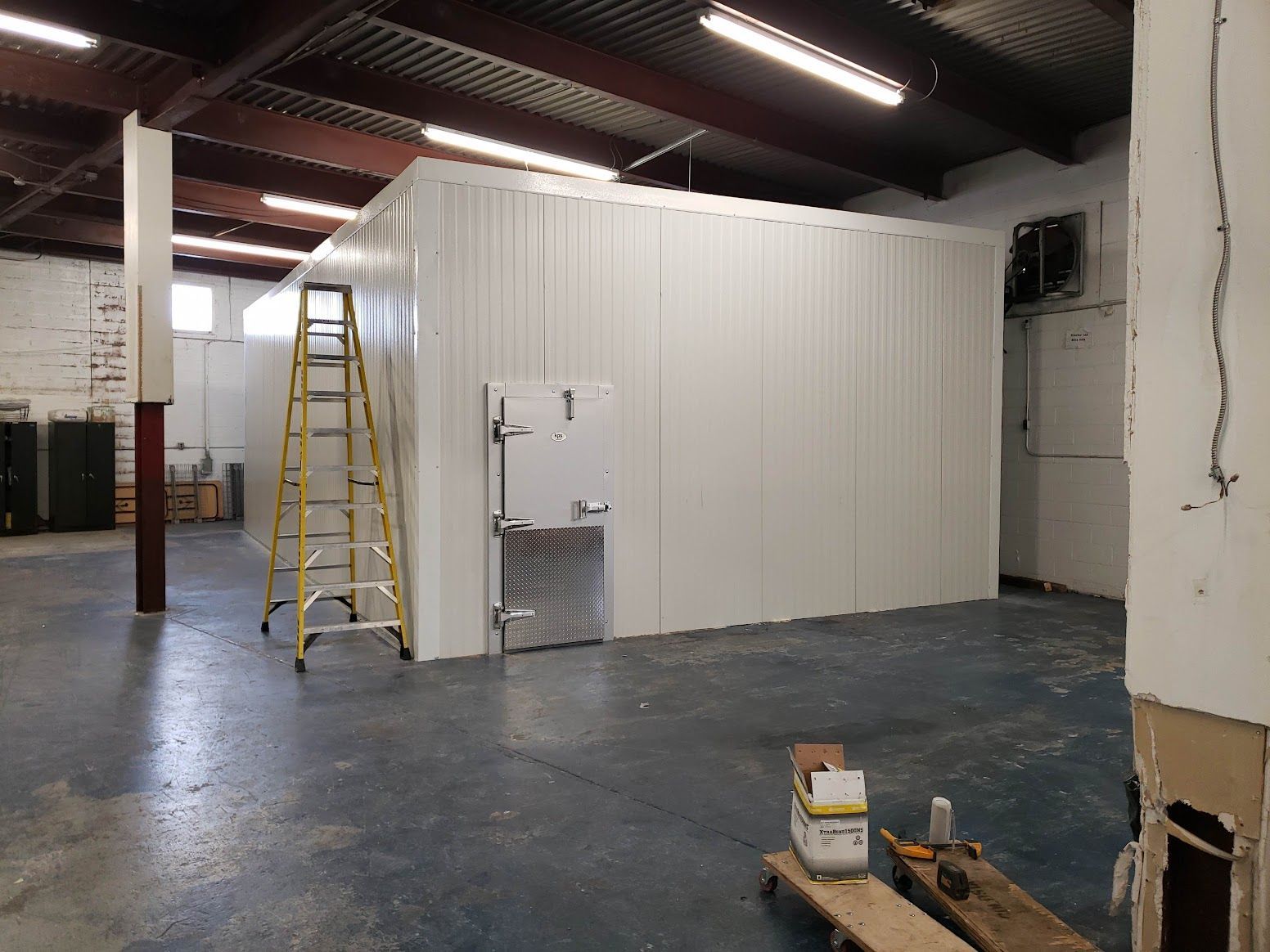 A warehouse with a ladder in the middle of it