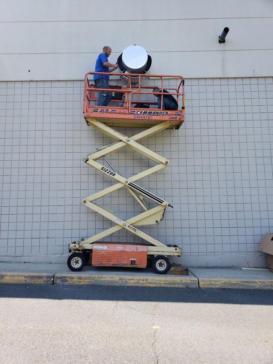A man on a scissor lift working on a brick wall
