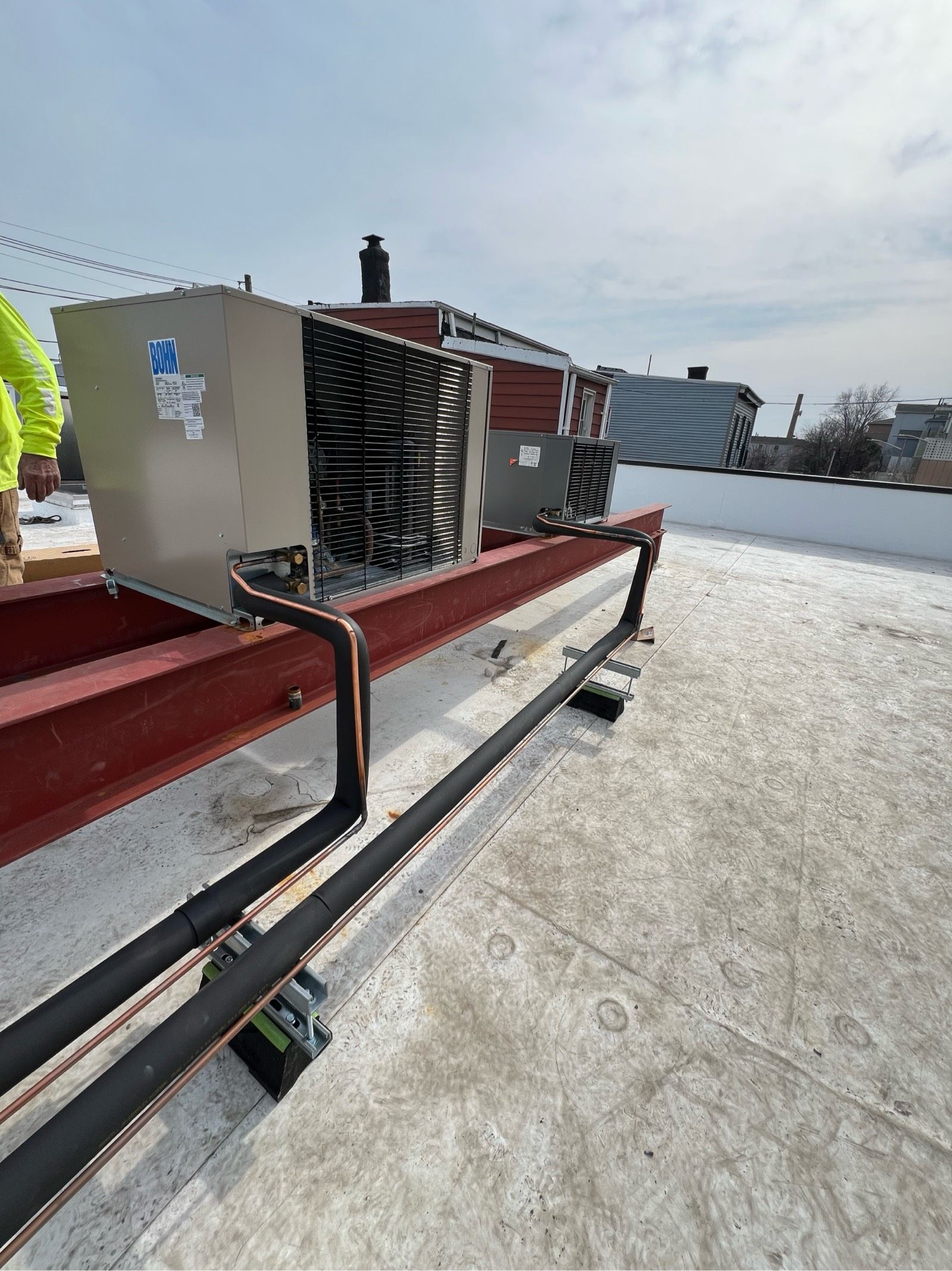 A man is standing on top of a snow covered roof.