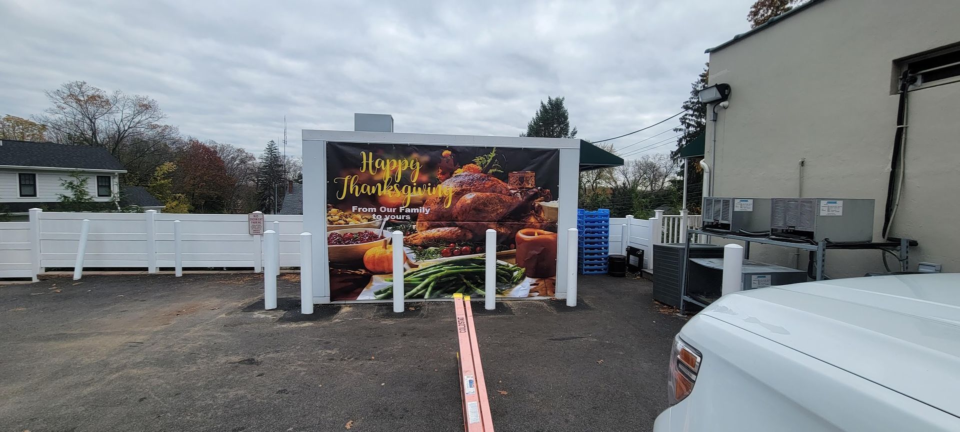 A food truck is parked in a parking lot next to a white truck.