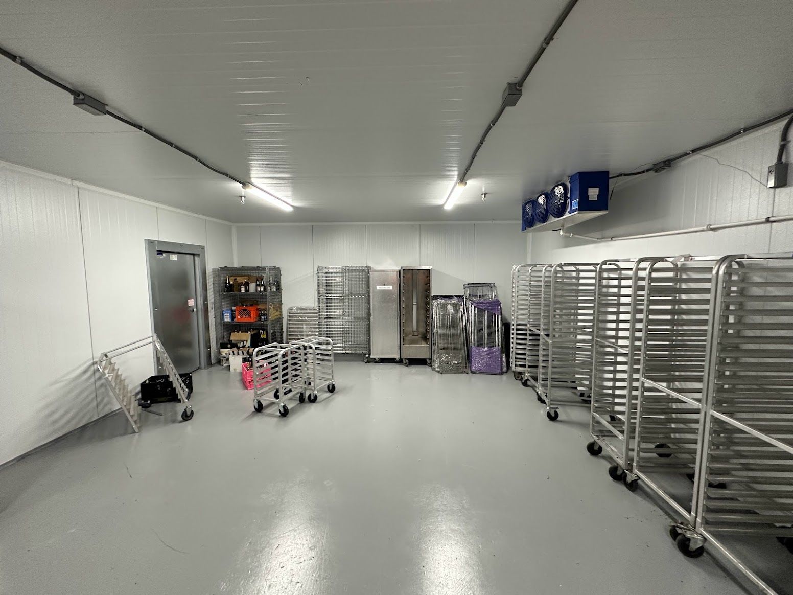 A large room with a lot of shelves and carts in it.