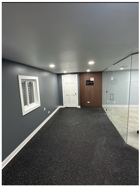 An empty room with a carpeted floor and a window.