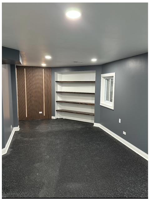 An empty room with a window and shelves in it