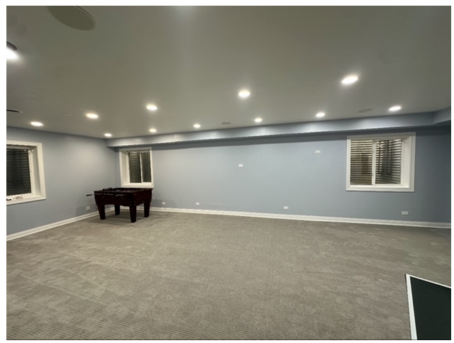 An empty room with a table and two windows