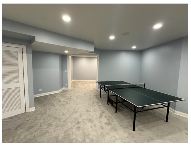 A basement with two ping pong tables in it